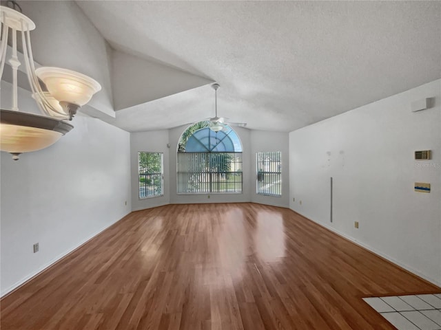 unfurnished room with hardwood / wood-style flooring, ceiling fan, a textured ceiling, and lofted ceiling