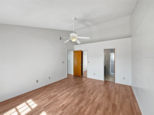 empty room with light hardwood / wood-style flooring, high vaulted ceiling, ceiling fan, and a textured ceiling