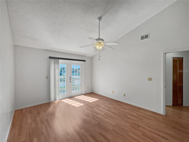 spare room with high vaulted ceiling, french doors, light hardwood / wood-style floors, ceiling fan, and a textured ceiling