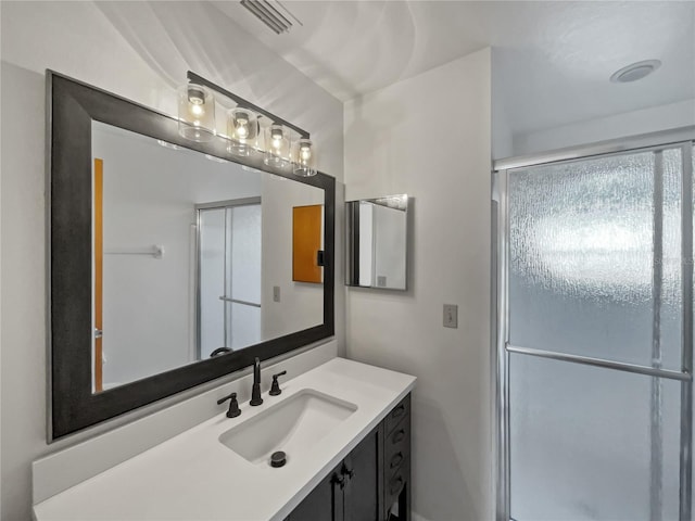 bathroom with vanity and a shower with door