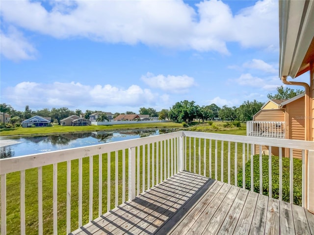 wooden terrace with a water view and a lawn