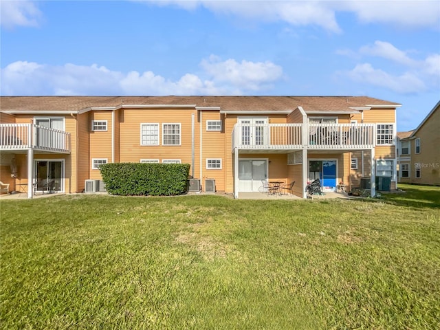 back of house with a patio area, a balcony, central AC unit, and a lawn