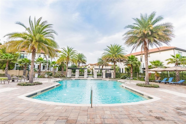 view of swimming pool with pool water feature and a patio area