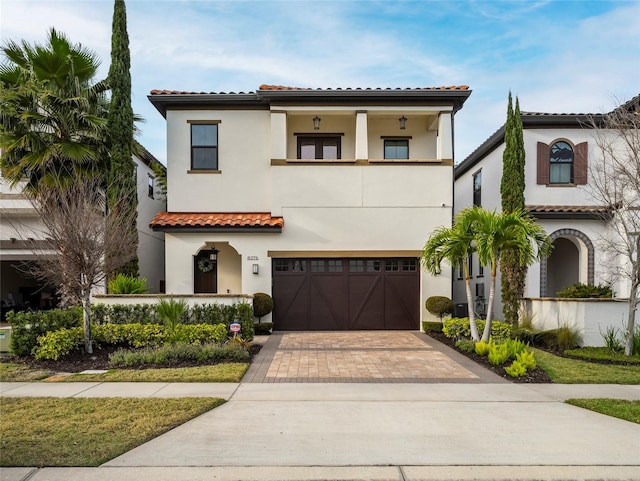 mediterranean / spanish-style house with a garage and a balcony