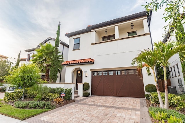 mediterranean / spanish home with a garage, central AC, and a balcony