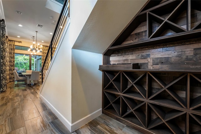 wine cellar featuring ornamental molding, a chandelier, and dark wood-type flooring