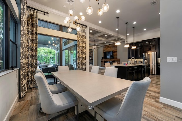 dining space featuring beamed ceiling, light wood-type flooring, a notable chandelier, and coffered ceiling