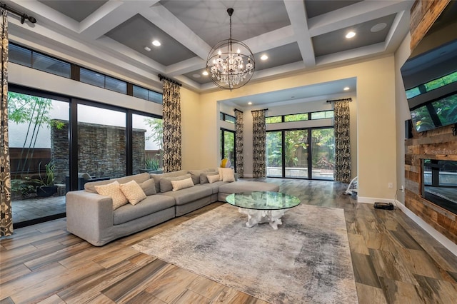 living room featuring hardwood / wood-style floors, a wealth of natural light, a notable chandelier, and coffered ceiling