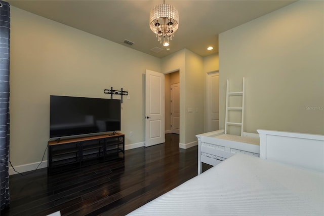 bedroom with dark hardwood / wood-style flooring and an inviting chandelier