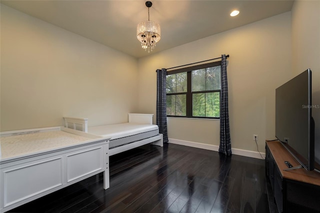 bedroom with a chandelier and dark wood-type flooring