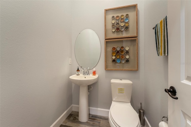 bathroom with hardwood / wood-style flooring and toilet