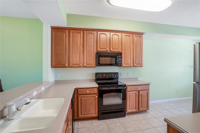 kitchen with sink, light tile flooring, and black appliances