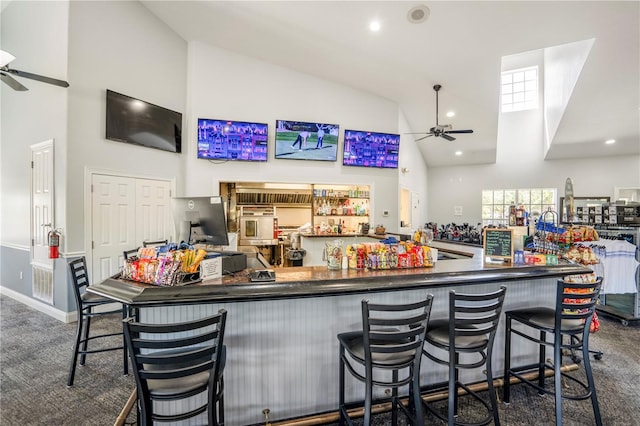 bar with high vaulted ceiling, ceiling fan, and dark carpet