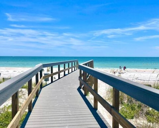 dock area with a water view and a view of the beach