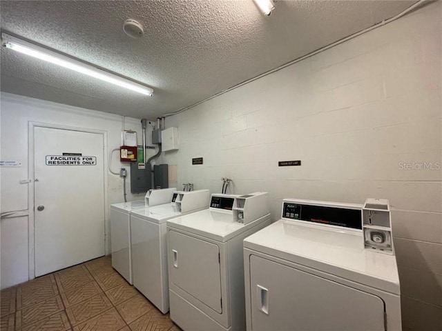 washroom with washer and clothes dryer and a textured ceiling