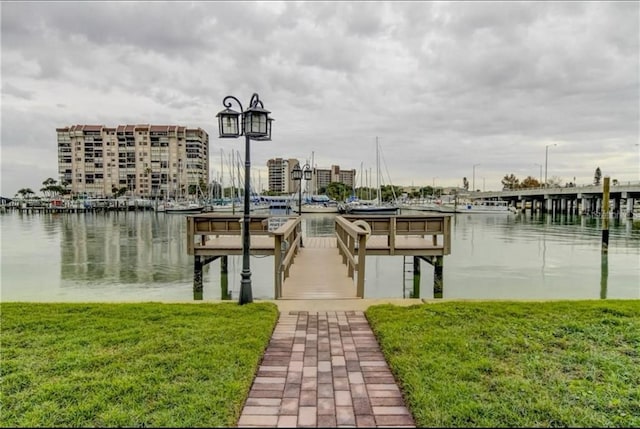 view of dock featuring a water view and a yard