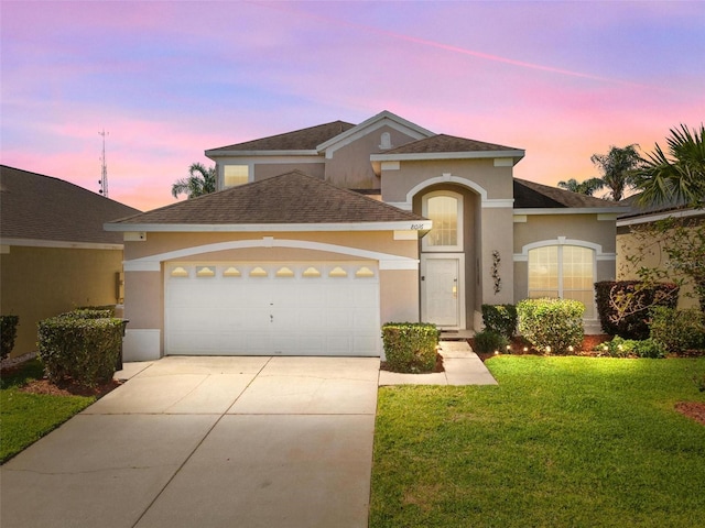 view of front of house with a garage and a yard