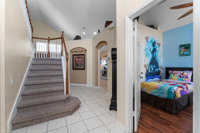 stairs featuring vaulted ceiling, ceiling fan, and light hardwood / wood-style flooring