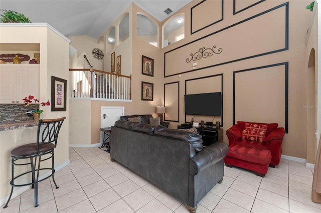 tiled living room featuring high vaulted ceiling