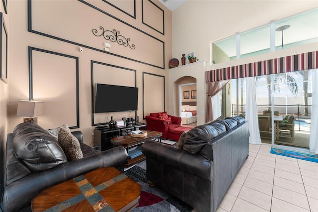 living room featuring a towering ceiling and light tile floors