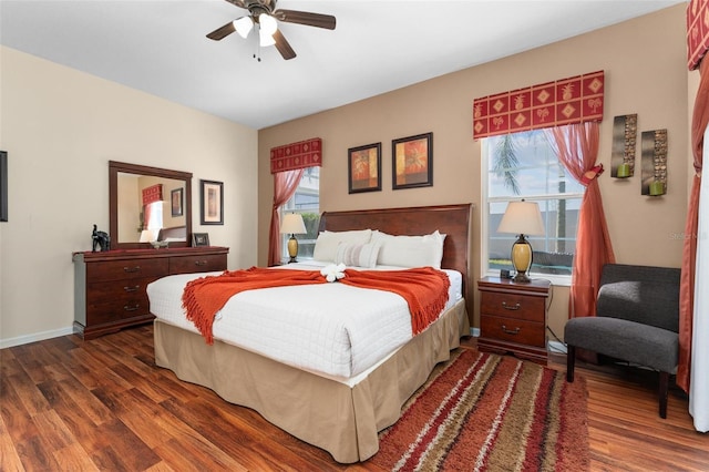 bedroom featuring ceiling fan, dark wood-type flooring, and multiple windows