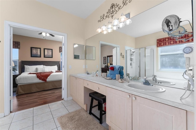 bathroom with vanity with extensive cabinet space, an enclosed shower, tile floors, double sink, and ceiling fan