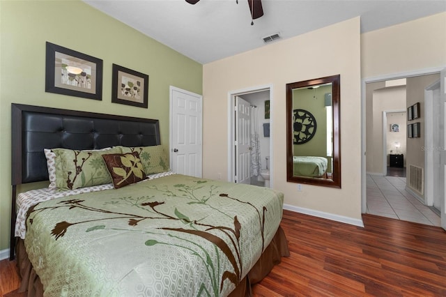 bedroom with ensuite bath, dark hardwood / wood-style flooring, and ceiling fan