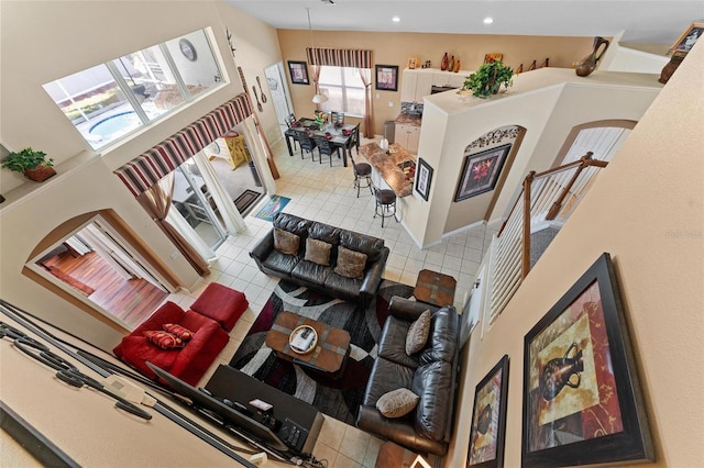 interior space with plenty of natural light, high vaulted ceiling, and tile flooring