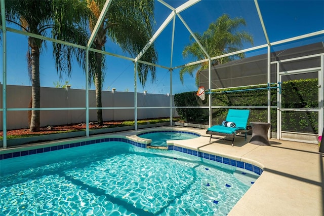 view of swimming pool featuring a patio, a lanai, and an in ground hot tub