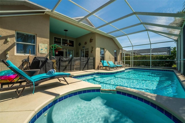 view of swimming pool featuring a patio, glass enclosure, and an in ground hot tub