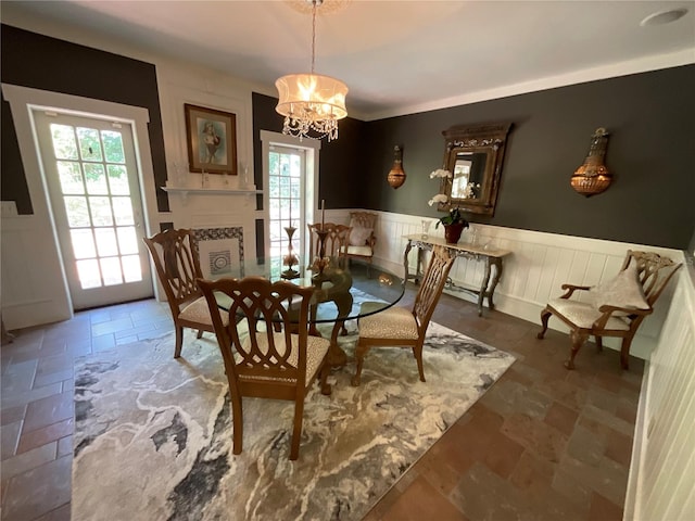 dining area with dark tile flooring and an inviting chandelier