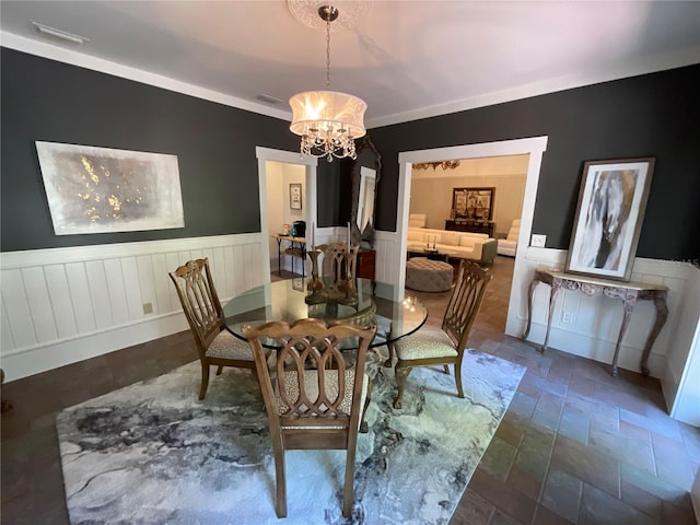 dining space with a chandelier and crown molding