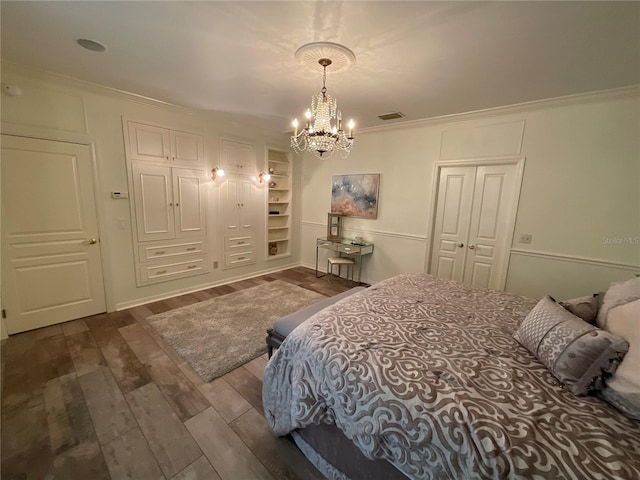 bedroom with dark hardwood / wood-style flooring, crown molding, and a chandelier