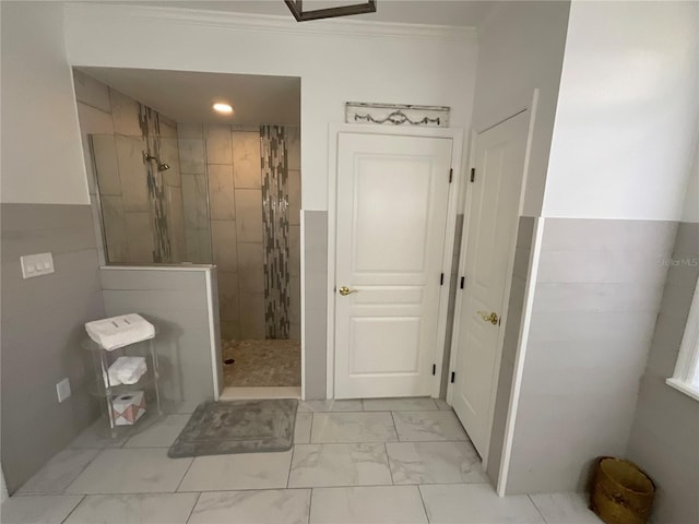 bathroom featuring ornamental molding, tiled shower, and tile floors