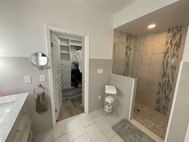 bathroom with tile floors, vanity, and a tile shower