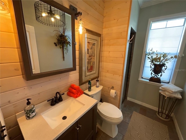 bathroom with wood walls, vanity, and toilet