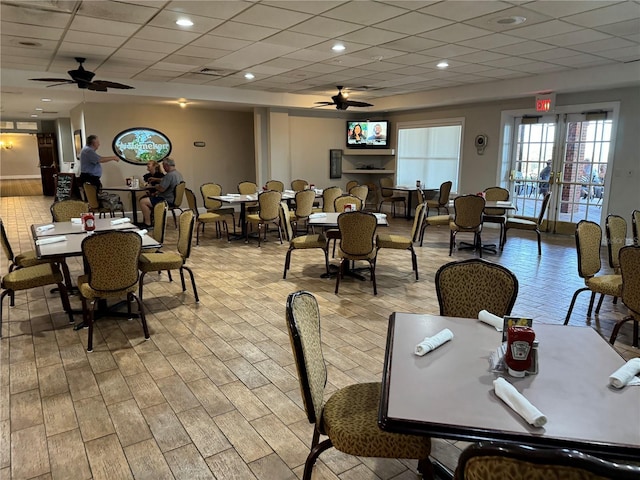 dining space featuring a drop ceiling, light hardwood / wood-style flooring, and ceiling fan