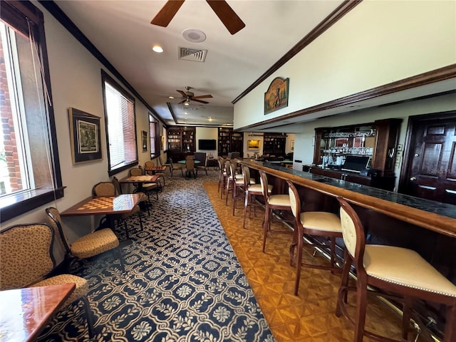 interior space with ornamental molding, ceiling fan, and parquet flooring