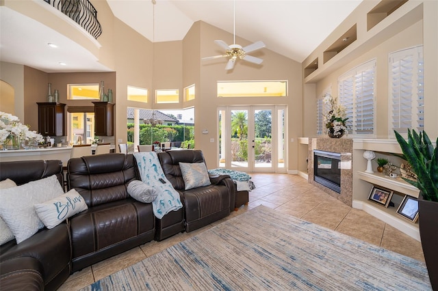 living room with a towering ceiling, french doors, ceiling fan, and light tile floors