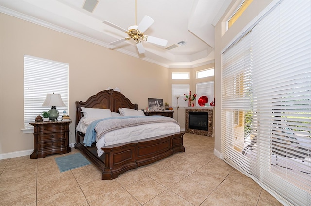 bedroom with ceiling fan, a high ceiling, light tile floors, and a tray ceiling