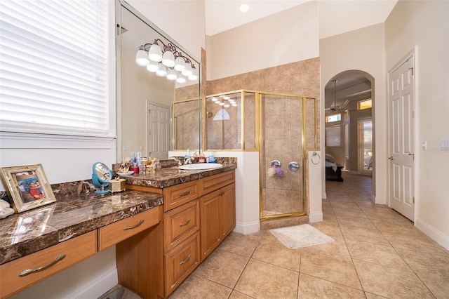 bathroom featuring a shower with door, a towering ceiling, tile flooring, and vanity