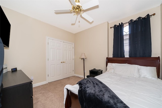 bedroom with a closet, ceiling fan, and light colored carpet