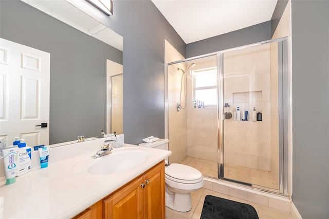 bathroom with tile floors, vanity, an enclosed shower, and toilet