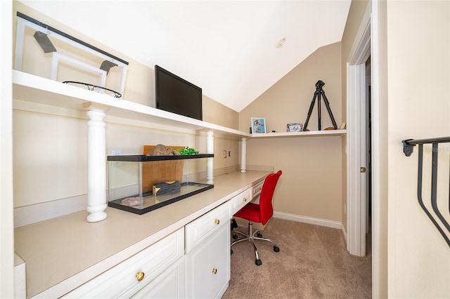 carpeted office with vaulted ceiling and built in desk