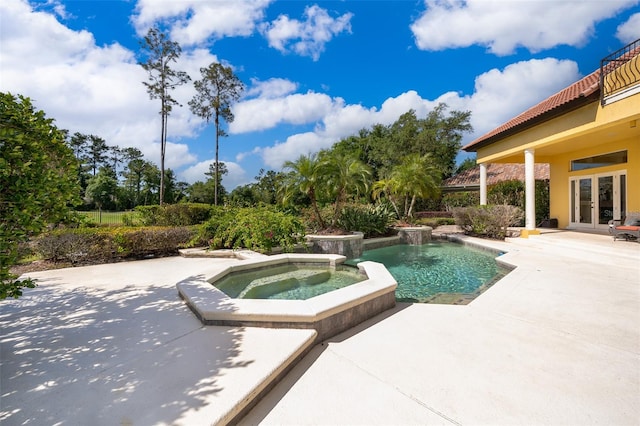 view of swimming pool with a patio, an in ground hot tub, and french doors