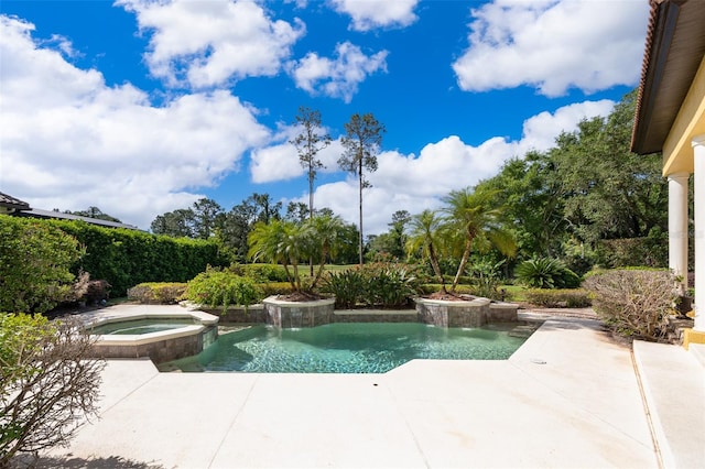 view of pool with an in ground hot tub, pool water feature, and a patio area