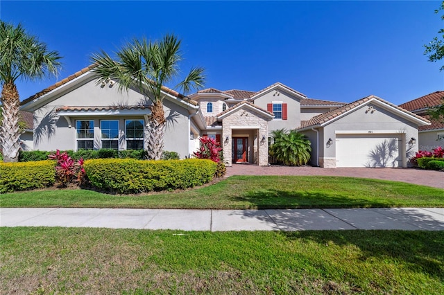 mediterranean / spanish-style house featuring a garage and a front lawn