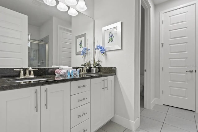 bathroom featuring tile floors, oversized vanity, toilet, and double sink