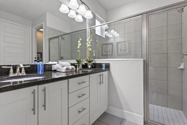 bathroom featuring large vanity, an enclosed shower, double sink, and tile flooring