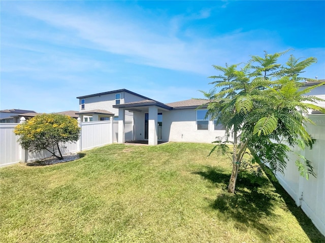 back of house with a lawn